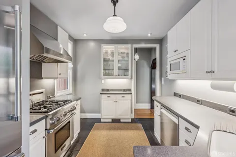 a kitchen with a sink cabinetry and chairs