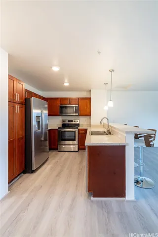 a kitchen with stainless steel appliances kitchen island granite countertop a refrigerator and a stove