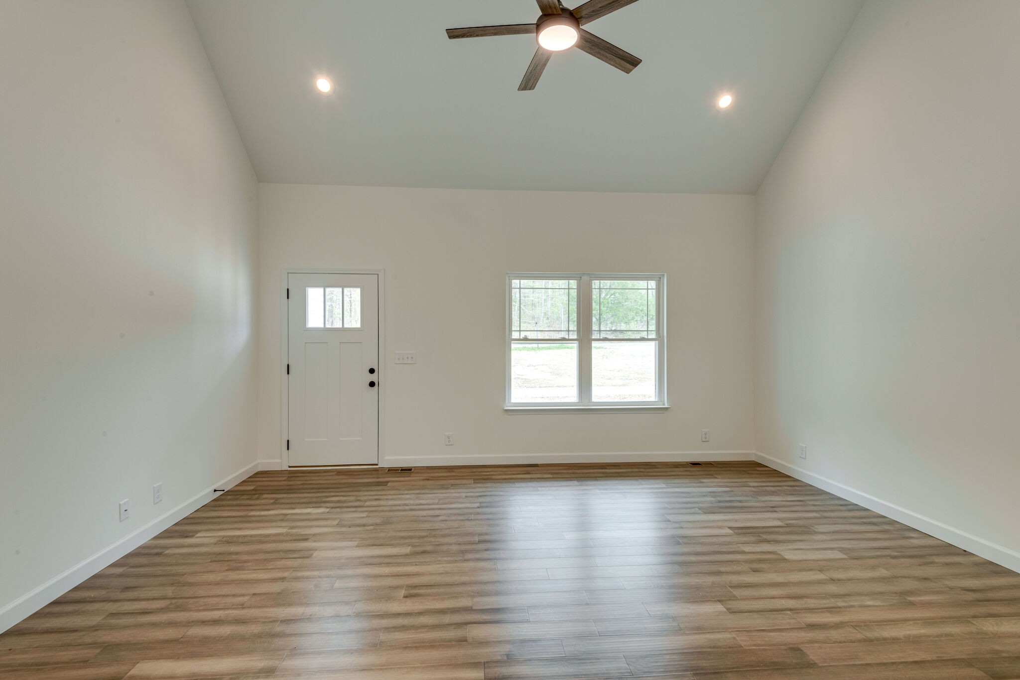 774 Lucas Road Dickson, TN 37055 - Photo 3 of 29 an empty room with wooden floor fan and windows