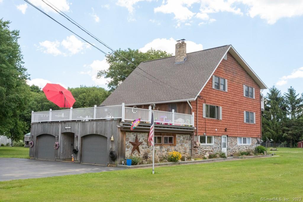 a front view of house with yard and trees in the background