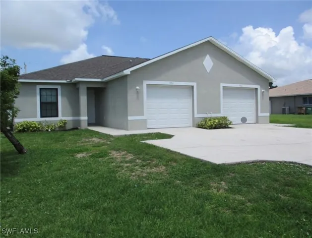 a front view of a house with a yard and garage