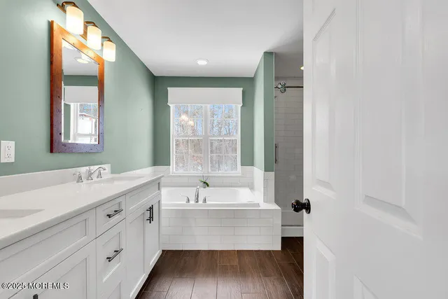 a bathroom with a tub sink and mirror