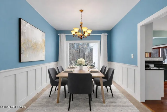 a dining room with furniture a large window and wooden floor