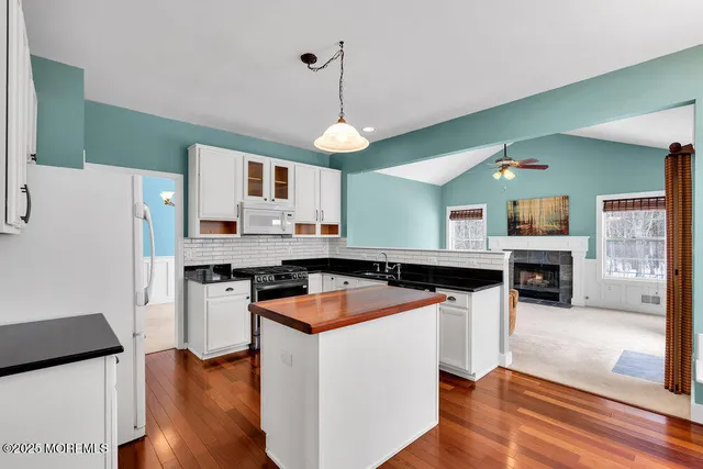 a kitchen with stainless steel appliances granite countertop a sink dishwasher a refrigerator and a stove with wooden floor