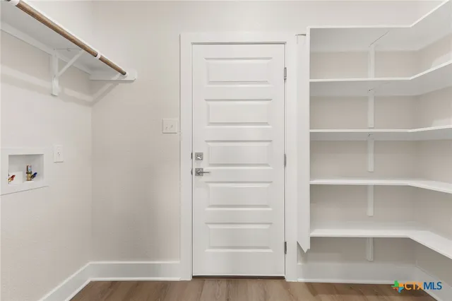 a view of walk in closet with empty racks