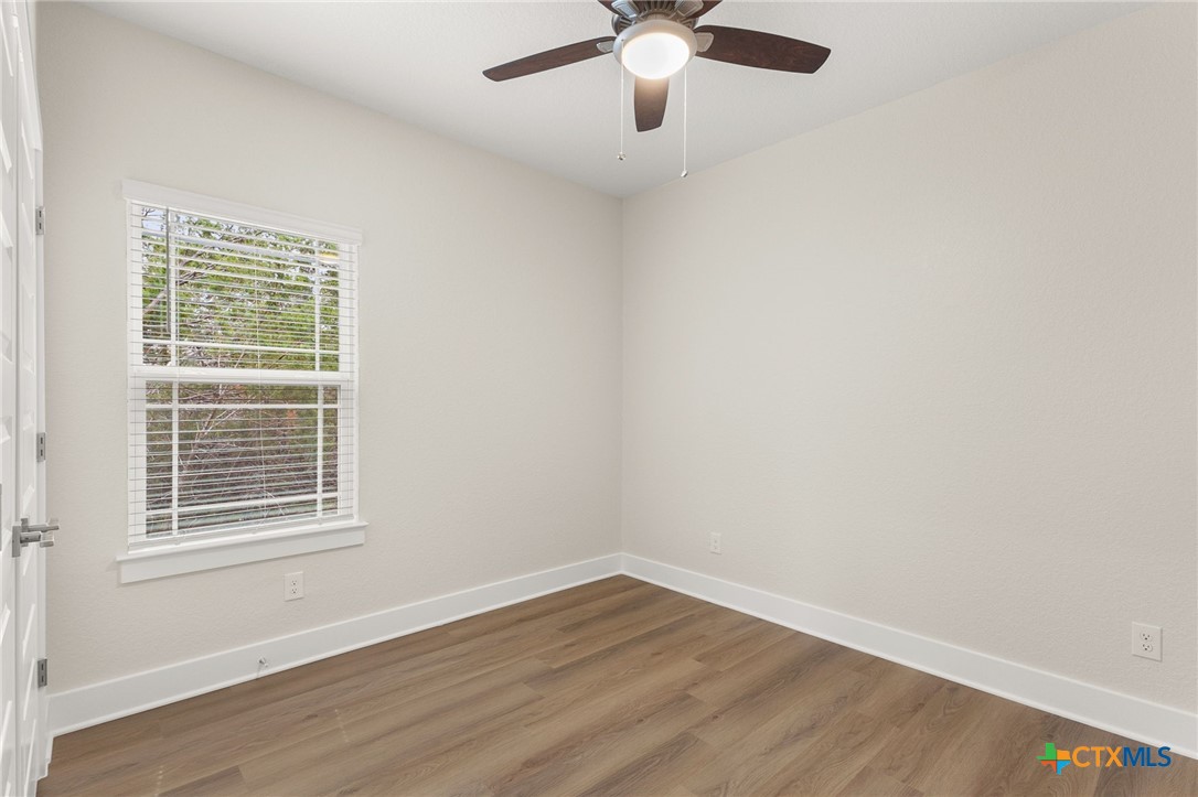 952 Rimrock Cove Spring Branch, TX 78070 - Photo 13 of 39 a view of an empty room with wooden floor and a window