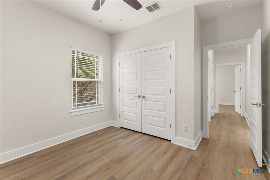 952 Rimrock Cove Spring Branch, TX 78070 - Photo 15 of 39 an empty room with wooden floor cabinet and windows