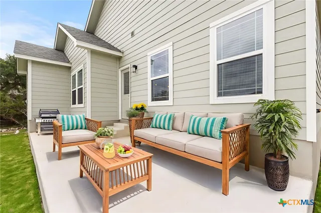 a view of a patio with couches table and chairs and potted plants