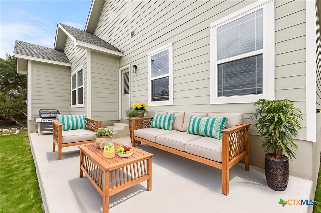 952 Rimrock Cove Spring Branch, TX 78070 - Photo 17 of 39 a view of a patio with couches table and chairs and potted plants