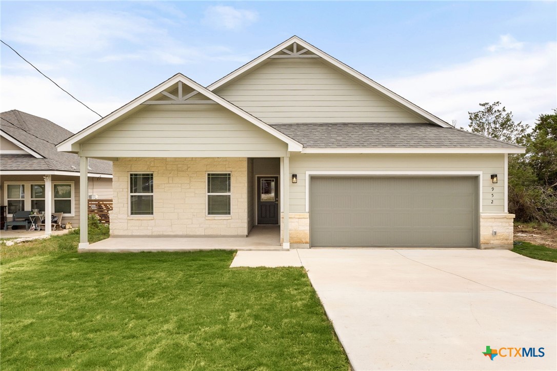 952 Rimrock Cove Spring Branch, TX 78070 - Photo 2 of 39 a front view of a house with a garden and yard