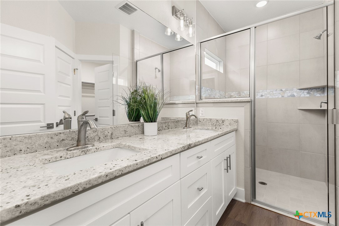 952 Rimrock Cove Spring Branch, TX 78070 - Photo 9 of 39 a bathroom with a granite countertop sink mirror and double