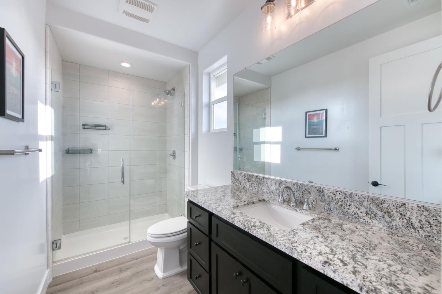 1736 North Renn Avenue Clovis, CA 93619 - Photo 33 of 66 a bathroom with a granite countertop sink a toilet and shower