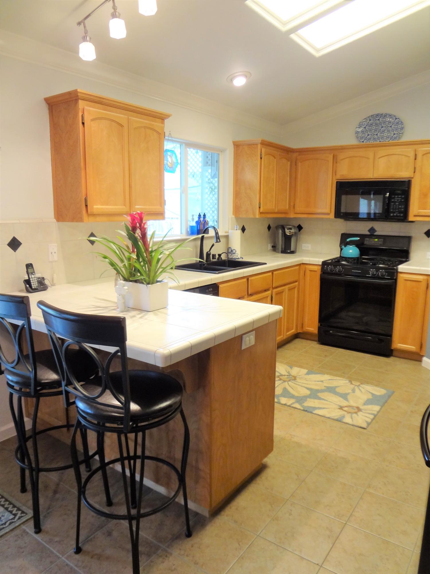 7759 Pit Road Redding, CA 96001 - Photo 9 of 47 a kitchen with granite countertop a table chairs sink and cabinets