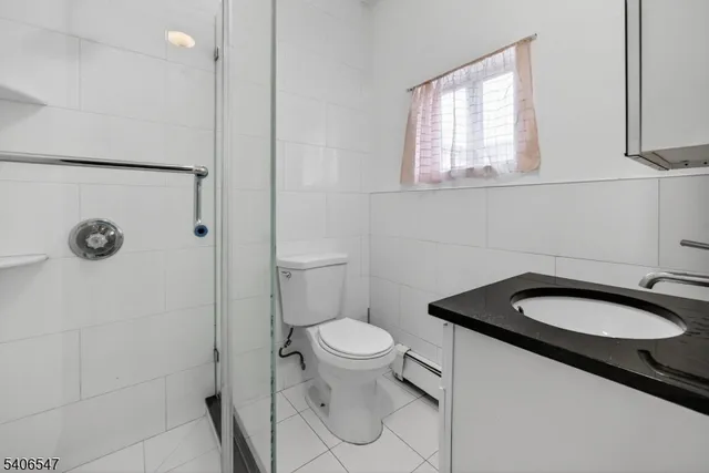 a bathroom with a granite countertop toilet a sink and a mirror