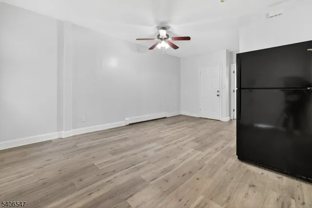 a view of a livingroom with wooden floor and a ceiling fan