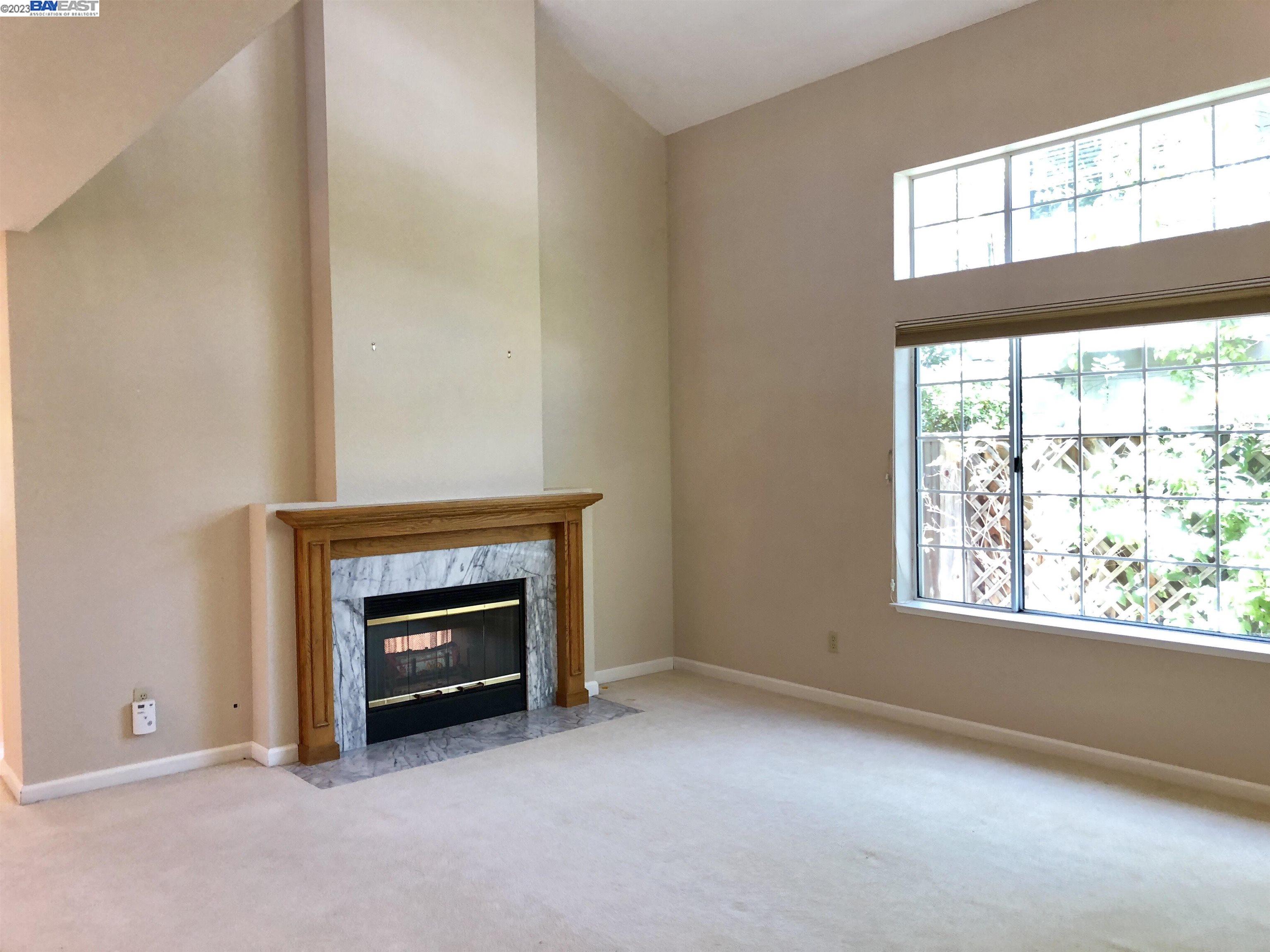 3047 Badger Drive Pleasanton, CA 94566 - Photo 6 of 18 an empty room with a fireplace and windows