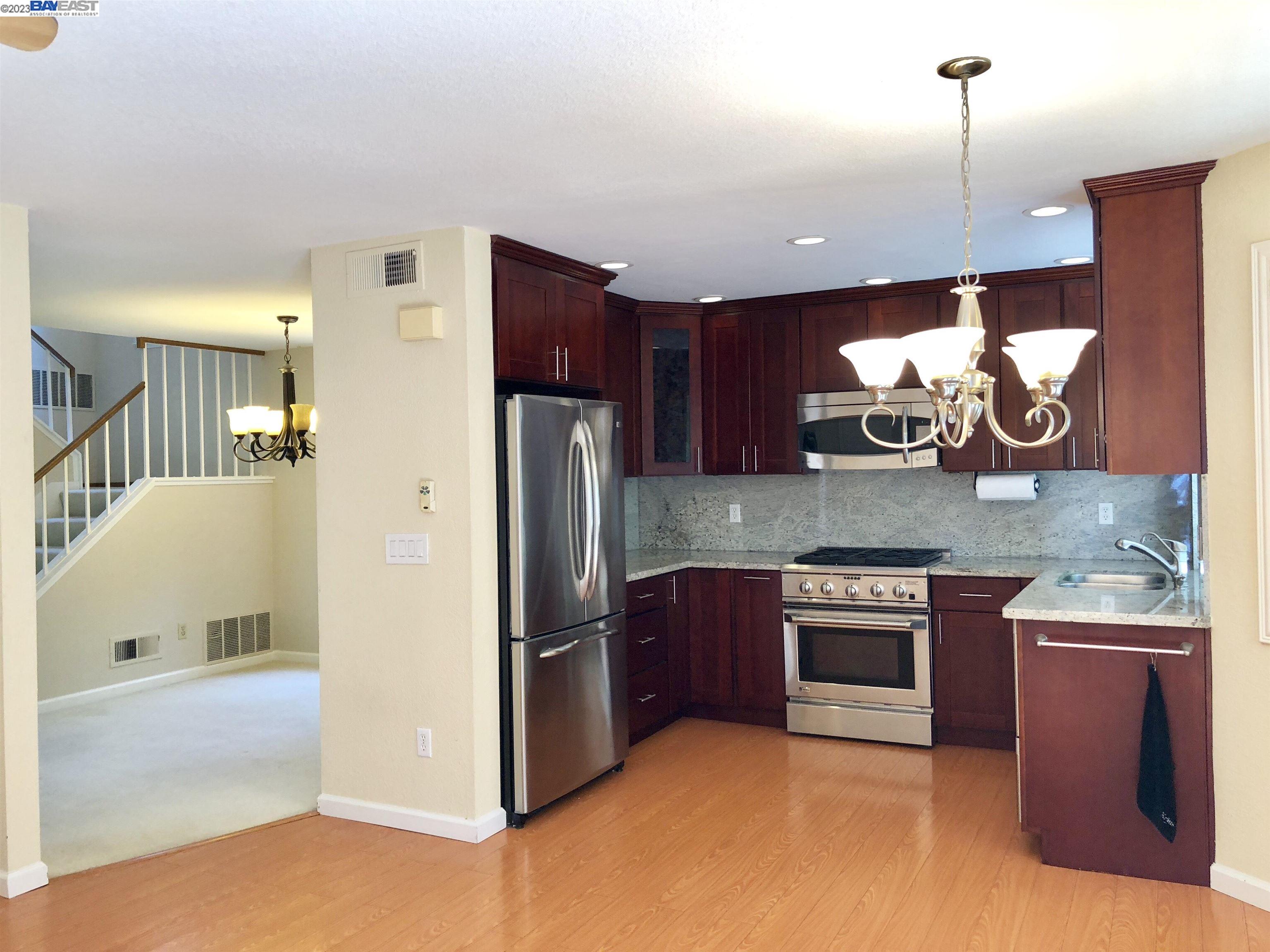3047 Badger Drive Pleasanton, CA 94566 - Photo 10 of 18 a kitchen with stainless steel appliances granite countertop a refrigerator a stove a sink and a microwave