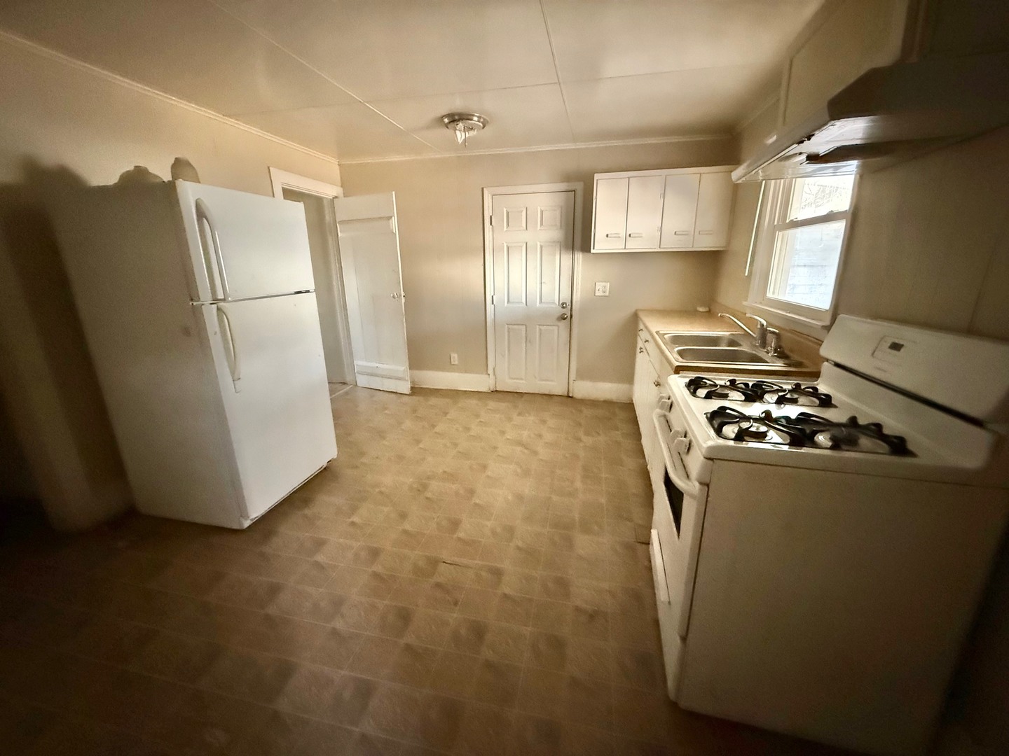 213 Northeast 4th Street Aledo, IL 61231 - Photo 10 of 15 a kitchen with stainless steel appliances a refrigerator a stove a sink and a window