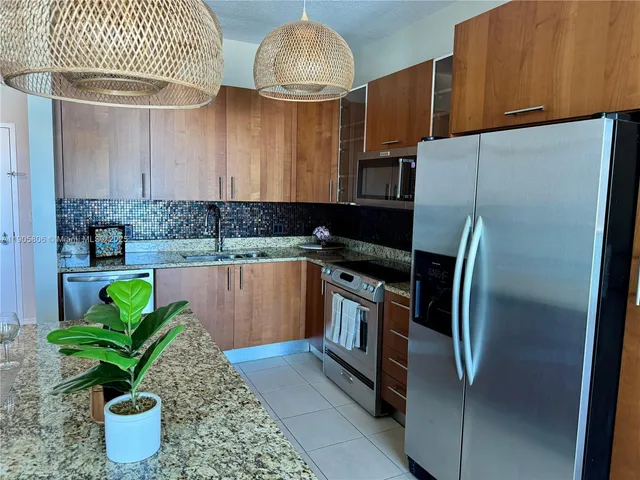 a kitchen with stainless steel appliances a stove a sink and a refrigerator