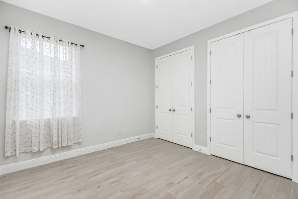 a view of a room with wooden floor and a window