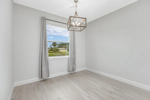 a view of a room with wooden floor fan and window