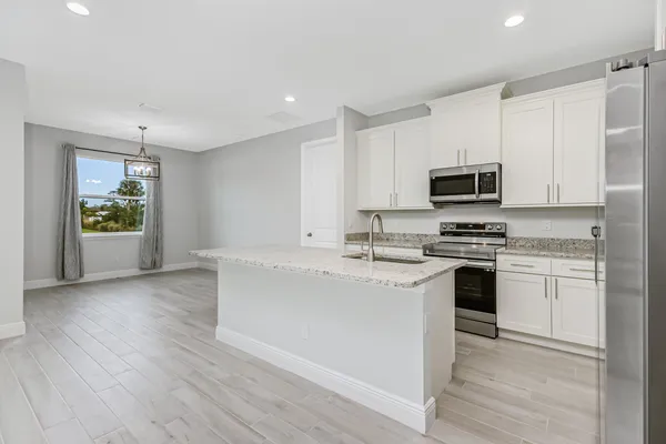 a kitchen with microwave a stove and cabinets