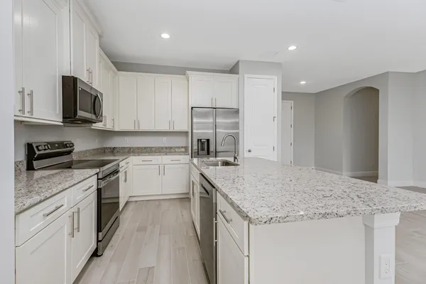 a kitchen with granite countertop white cabinets and white stainless steel appliances
