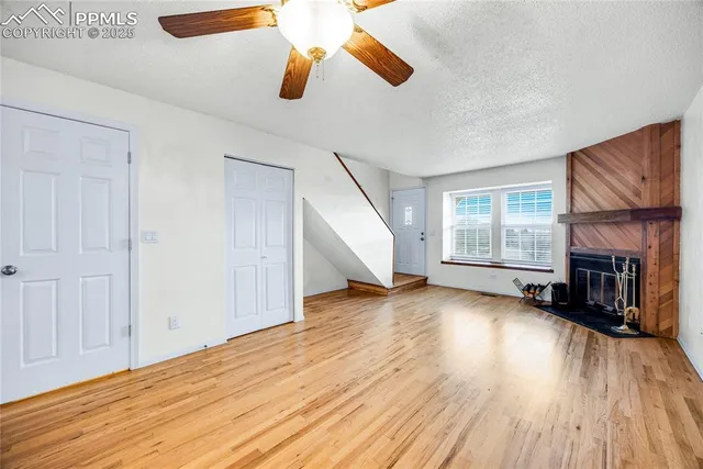 a view of an empty room with window and wooden floor