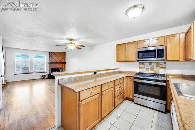 a kitchen with stainless steel appliances a stove microwave and sink
