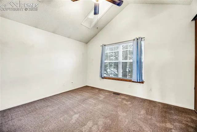 a view of a livingroom with a chandelier fan and a window