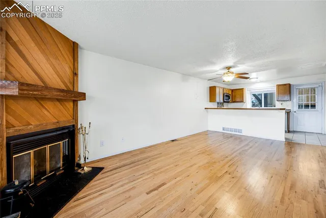 a view of a kitchen with wooden floor and a window