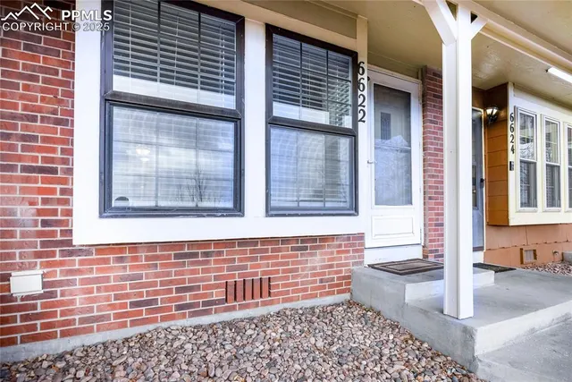 a view of a living room with wooden floor and a ceiling fan