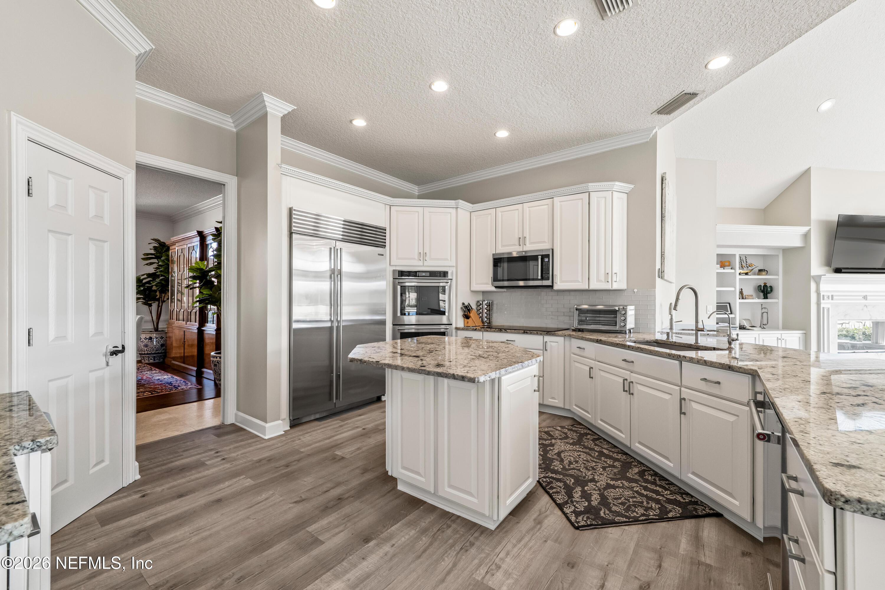 205 Royal Tern Road North Ponte Vedra Beach, FL 32082 - Photo 51 of 85 a kitchen with stainless steel appliances granite countertop a refrigerator a sink dishwasher a stove and white cabinets with wooden floor