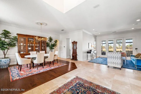 a kitchen with stainless steel appliances granite countertop a refrigerator a sink dishwasher a stove and white cabinets with wooden floor