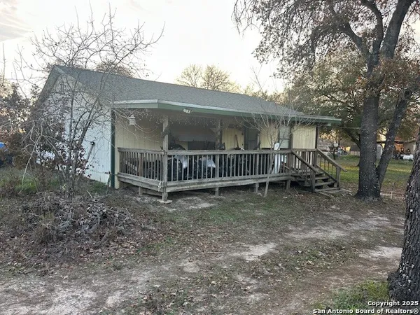 a view of a house with a yard and a wooden fence
