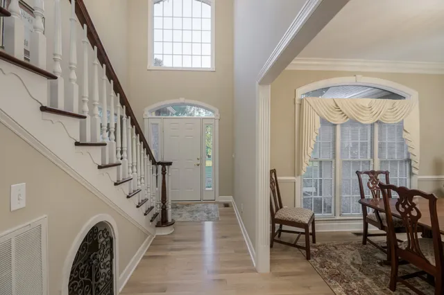 a kitchen with stainless steel appliances kitchen island granite countertop a sink a stove a refrigerator cabinets and chairs