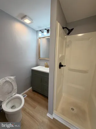 a bathroom with a granite countertop sink toilet and shower