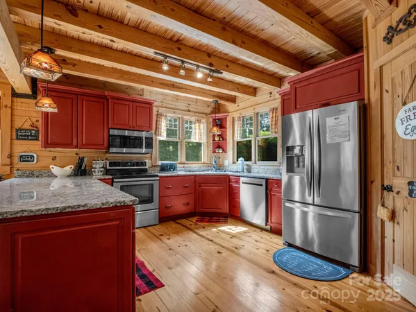 a kitchen with stainless steel appliances granite countertop a refrigerator a stove and a sink