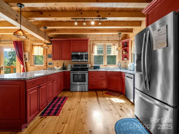 a kitchen with stainless steel appliances a refrigerator a sink a stove and cabinets