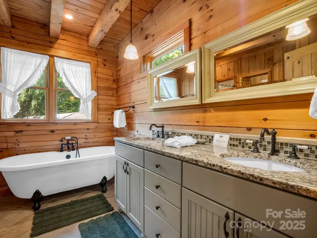 a bathroom with a granite countertop sink and a window