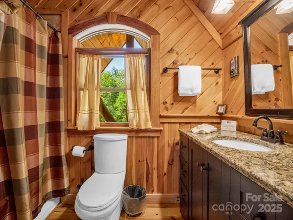 a bathroom with a granite countertop sink mirror vanity and toilet