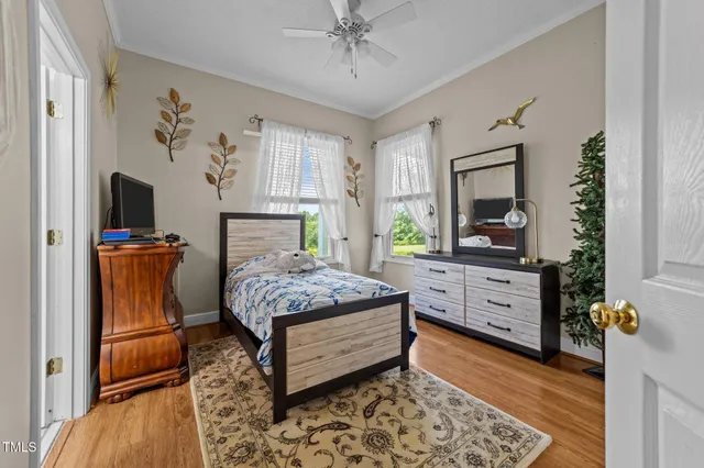 a bedroom with a bed dresser and flat screen tv