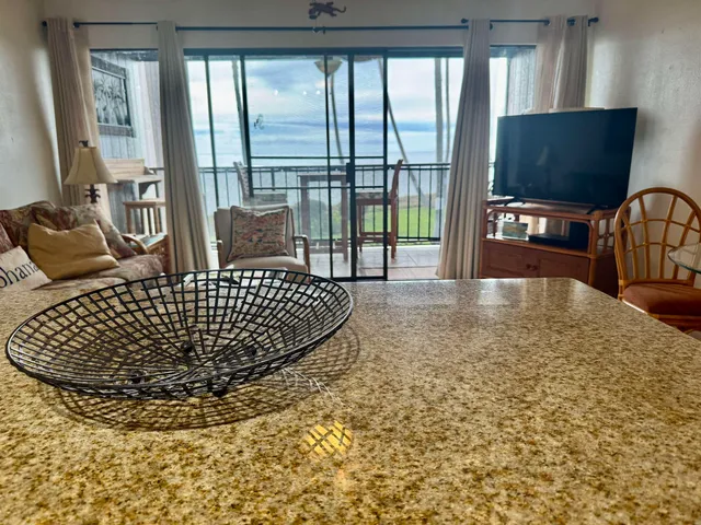a kitchen with kitchen island granite countertop a table chairs microwave and cabinets