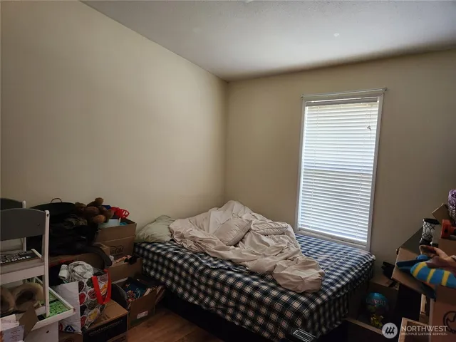 a bedroom with a bed and wooden floor