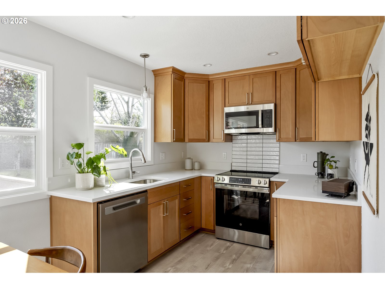 4750 Southwest Larch Drive Beaverton, OR 97005 - Photo 21 of 48 a kitchen with stainless steel appliances a sink a stove a refrigerator cabinets and a window