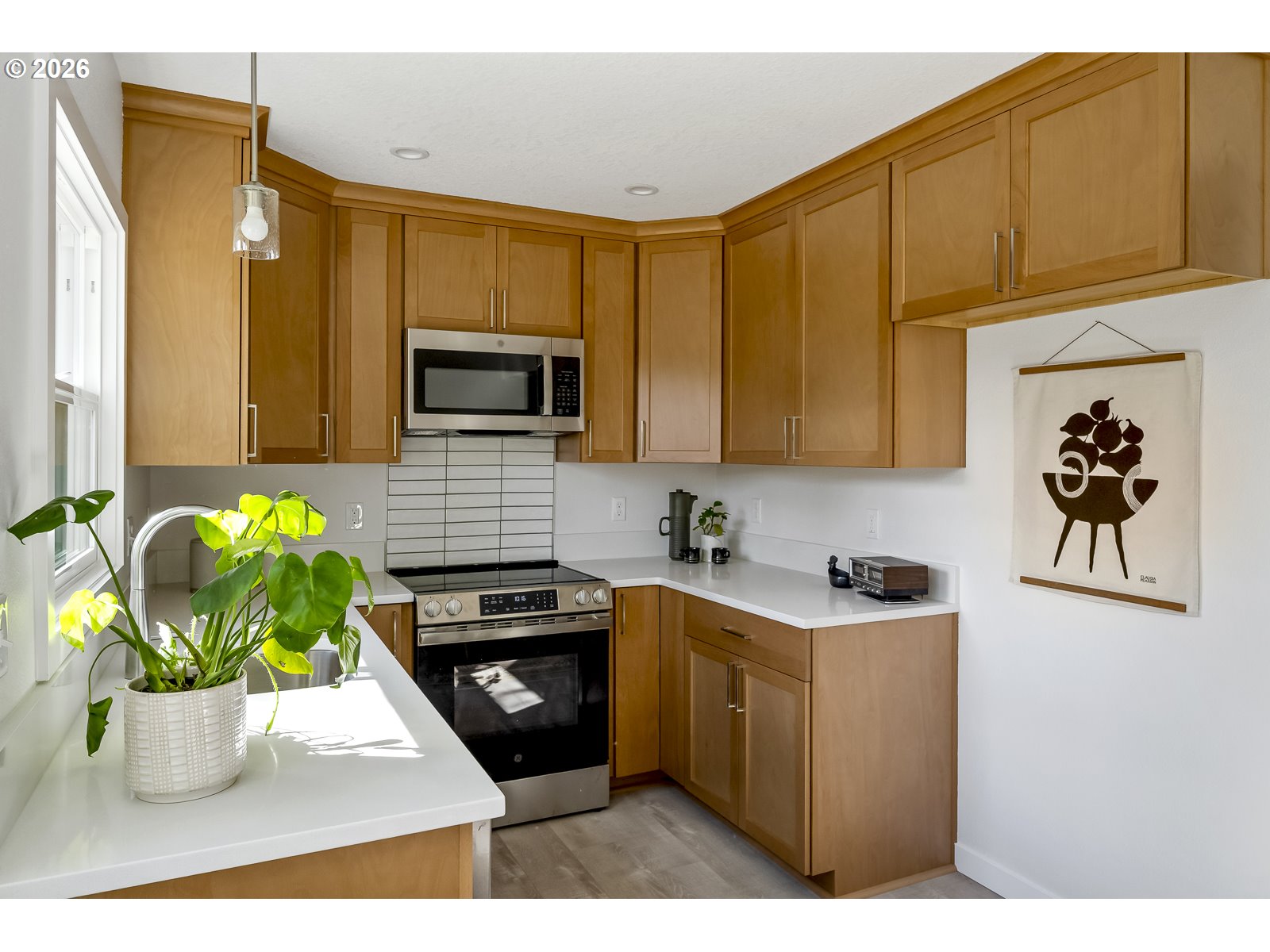 4750 Southwest Larch Drive Beaverton, OR 97005 - Photo 22 of 48 a kitchen with a stove a microwave a sink and cabinets