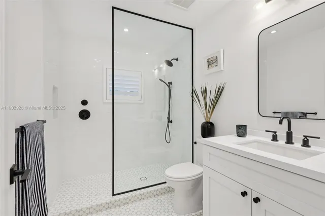 a bathroom with a granite countertop sink toilet and a mirror