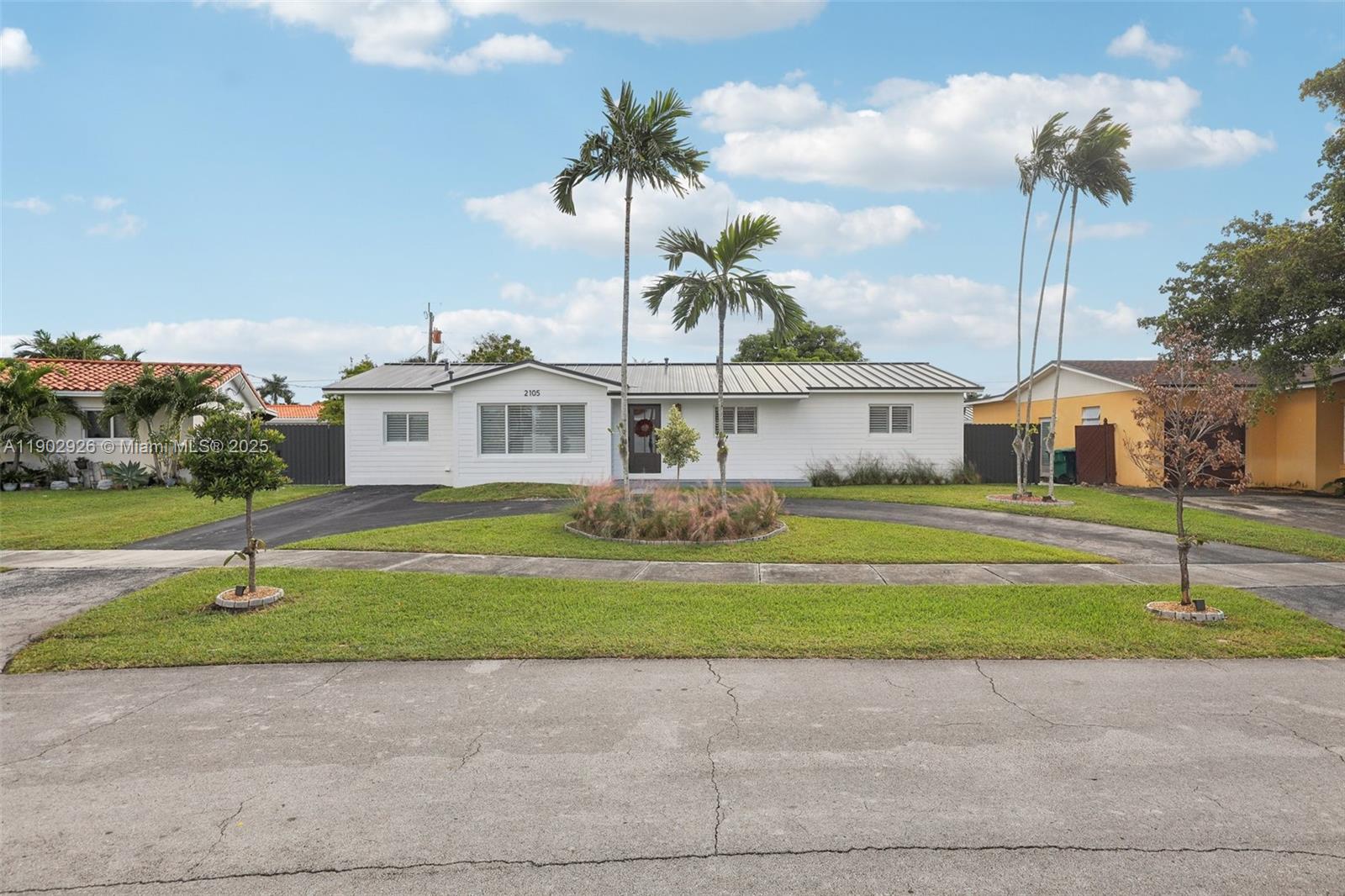 2105 Southwest 98th Avenue Miami, FL 33165 - Photo 59 of 88 a front view of a house with a garden and yard