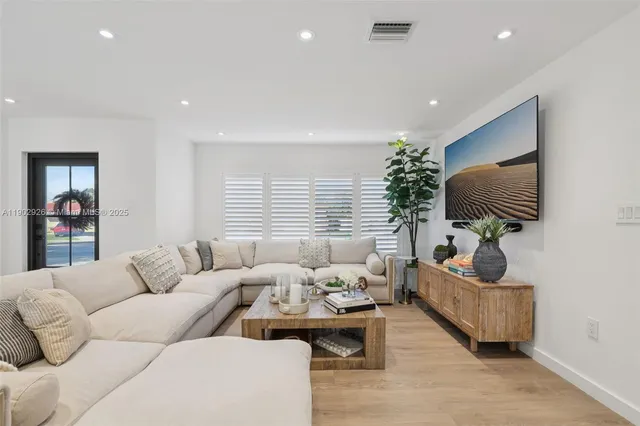a living room with furniture and a potted plant