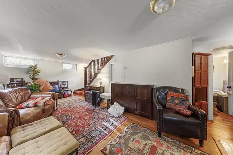 a kitchen with stainless steel appliances granite countertop a sink dishwasher a refrigerator a microwave oven with white cabinets and wooden floor